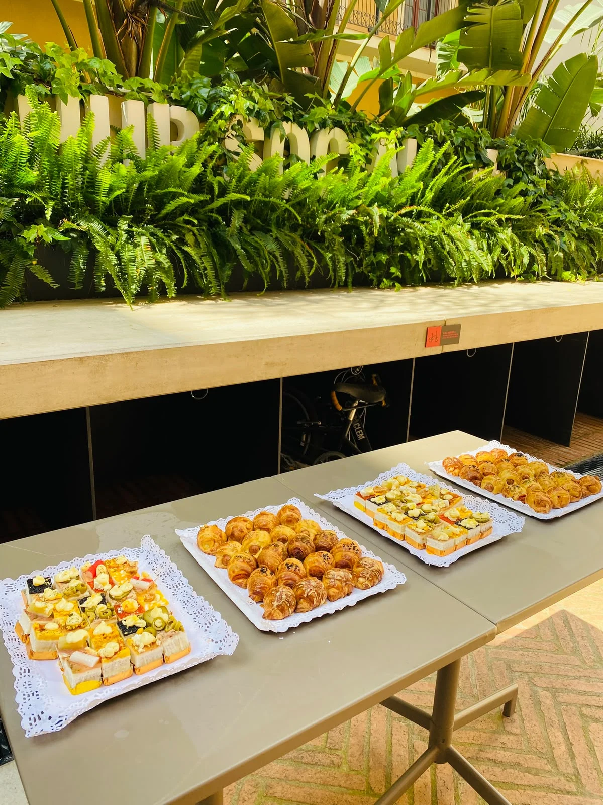 Montaje de mesa de cóctel con bandejas de canapés y mini croissants
